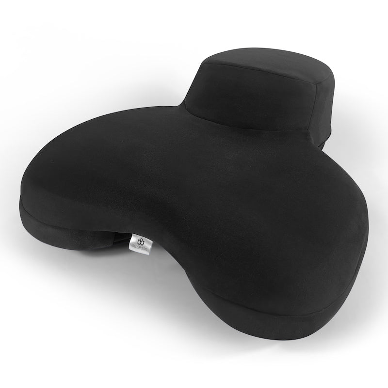 The black BIG Spoon cuddle pillow designed for couples to watch television, with arm tunnels and shoulder nooks for comfort.